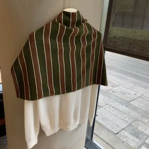 Detailaufnahme des gestreiften Strick-Capes mit weißem Pullover, Herbst-Winter-Modell