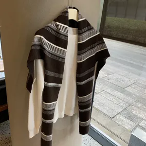 Nahaufnahme eines Retro gestreiften Strickschals und Überwurfs, hängende Schichtungspräsentation.
