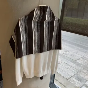 Detailansicht des gestreiften Strickschals im koreanischen Stil über weißem Pullover im Winter.