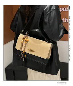 Vista dettagliata della borsa a tracolla retro bicolore con chiusura e ciondolo di perle.