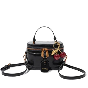 Sac à main fourre-tout pour femme en cuir vernis noir élégant avec poignée et charm cerise.