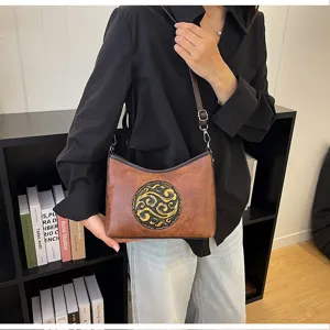 Vue détaillée du sac porté épaule en cuir véritable style chinois avec motif vintage gaufré.