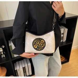 Élégant sac à bandoulière en cuir véritable style chinois avec un motif rond gaufré.