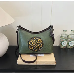 Vue détaillée du sac porté épaule en cuir vert style chinois avec motif doré gaufré.