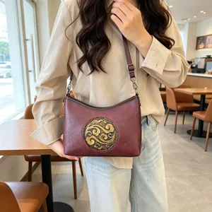 Sac à bandoulière vintage en cuir véritable pour femme avec motif doré en relief.