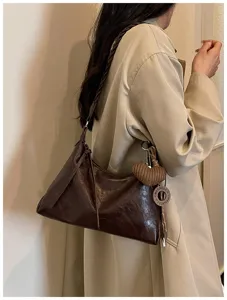 Vue détaillée du sac porté épaule marron foncé avec bandoulière tressée élégante.
