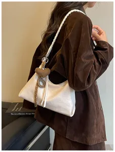 Gros plan détaillé d'un sac porté épaule hobo blanc élégant avec bandoulière tressée.