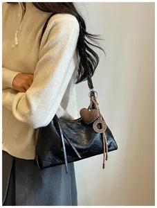 Sac à épaule noir chic avec bandoulière tressée et charm cœur, idéal pour le quotidien.