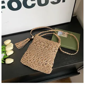 Woven straw crossbody bag detail, cute small cell phone purse with tassel and long braided strap.