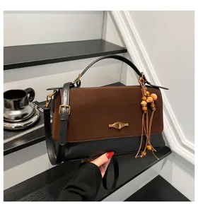 Primo piano dettagliato che mostra il design bicolore, la patta in camoscio e le perle.