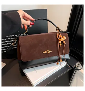 Borsa a tracolla in camoscio marrone con fondo in pelle nera e ciondoli di perline in legno.