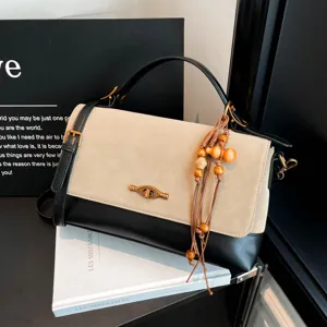 Borsa a tracolla elegante da donna in camoscio con ciondolo in legno e chiusura a girello.