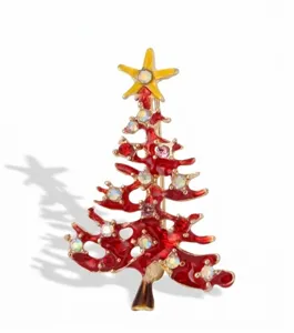 Detailed view of a Christmas tree brooch featuring red enamel, rhinestones, and gold-tone finish.