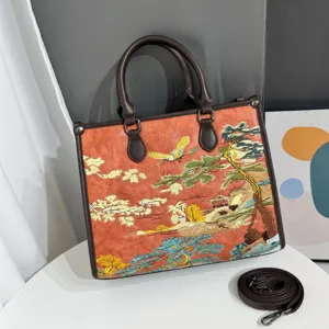 Primo piano dettagliato della borsa tote con ricamo paesaggistico cinese e manici marroni.