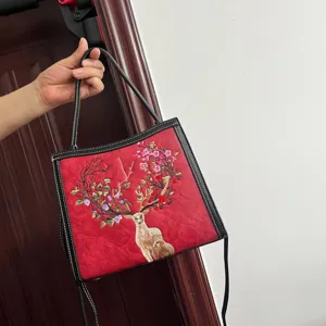 Detailed view of red embroidered deer shoulder bag with stylish traditional design