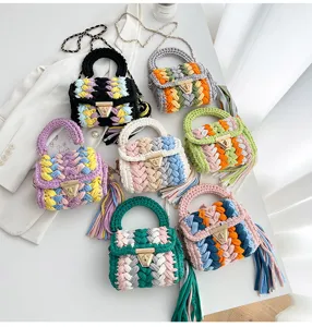 Sac à main crocheté à la main avec design tissé coloré, fermoir en métal et pompon.