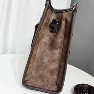 Primo piano sul dettaglio del tassello laterale e dell'anello in pelle marrone.