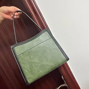 Green contrast shoulder bag detail, stylish women tote purse with black trim and handle.