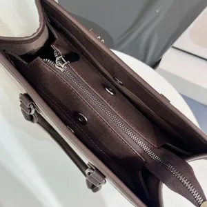 Vista dettagliata dell'interno della borsa marrone con cerniera e bottoni magnetici.