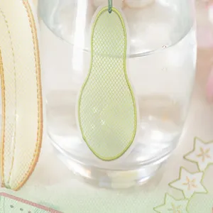 Detalle pegatina marcapáginas organza malla verde, artículo artesanal papetería DIY creativo.