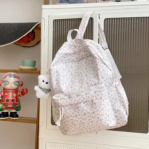 Schoolrugzak met bloemenprint en schattige berenhanger, gezellige esthetische detailweergave.