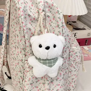 Detail van een schattige witte pluche berenhanger op een Japanse bloemenrugzak.