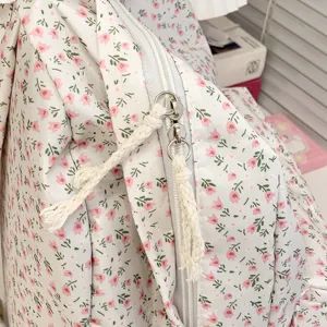 Detailopname van de schattige roze bloemenrugzak met rits en zachte stoftextuur.