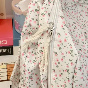 Detailopname van de bloemenrugzak met schattige ritssluitingen en fijne stoftextuur.