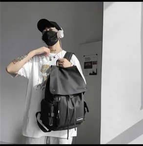 Detailansicht des schwarzen Streetstyle-Rucksacks mit mehreren Taschen und Kordelzug.