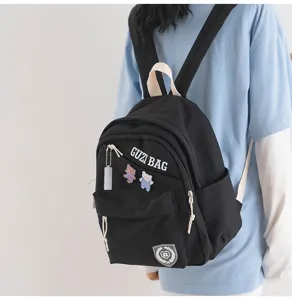 Detail view of the black small mini backpack with cute bear pins and straps, casual style.