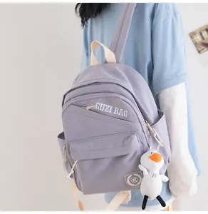 Detail view of a lightweight small purple backpack with cute duck pendant for daily casual wear.