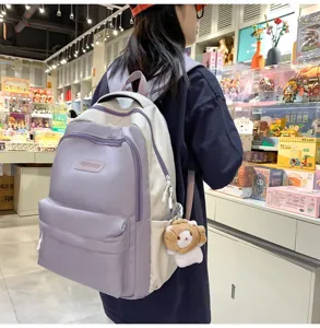 Vista dettagliata dello zaino bicolore elegante con tasca frontale e grazioso ciondolo in peluche.