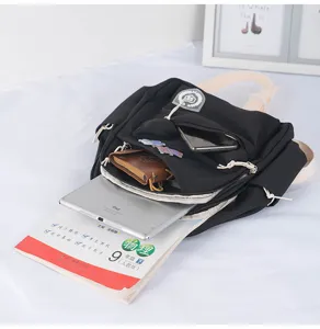 Detailed scene showing the compact black backpack interior capacity with books and digital tablet.