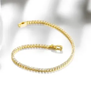 Nahaufnahme des eleganten goldenen Tennisarmbands mit funkelnden runden Zirkoniasteinen.