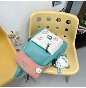 Colorful casual backpack for students, stylish school bag with badges and cute plush pendant.