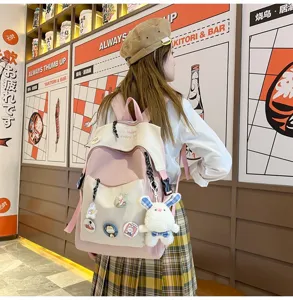 Trendy casual pink student backpack with cute charms and spacious compartments for daily use.