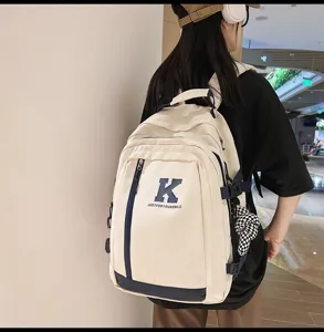 Λεπτομερής εικόνα από casual καμβά σακίδιο πλάτης με τύπωμα Κ, μεγάλη μπεζ σχολική τσάντα.