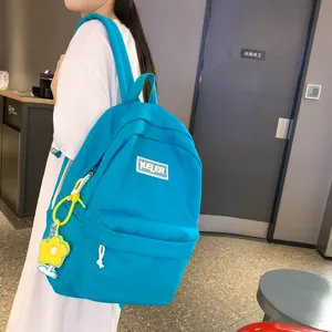 Blue canvas backpack for women, large capacity school bag with cute pendant and front pocket.