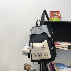 Casual canvas backpack for students, stylish black and grey design with cute bunny pendant.