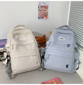 Vista detallada de la mochila de lona lisa casual con múltiples bolsillos y colgantes