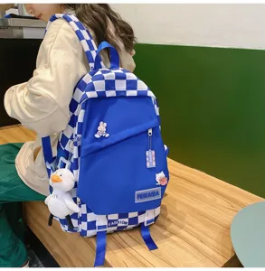 Zaino scolastico a quadri blu e bianco con simpatico ciondolo d'anatra e capienza.