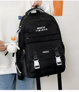 Zaino nero casual di grande capacità con tasche anteriori, fibbie e ciondolo anatra.