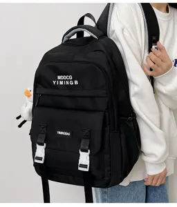 Vista dettagliata di uno zaino casual nero da studente con tasche anteriori e ciondolo anatra.