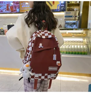 Vista dettagliata zaino a quadri rossi e bianchi, ciondolo peluche papera, stile harajuku.