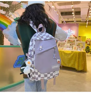 Dettagli dello zaino scozzese viola con ciondoli graziosi, leggero e alla moda.