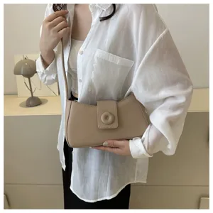 Vue détaillée du sac porté épaule beige tendance avec fermoir rond et finition lisse.