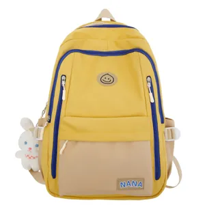 Lockerer gelber Studentenrucksack aus Canvas mit blauen Reißverschlüssen und süßem Häschenanhänger.