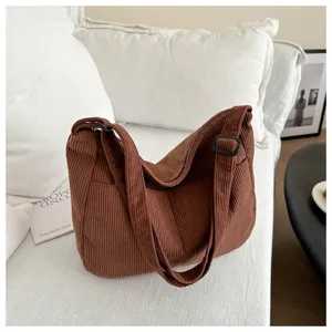 Sac bandoulière en velours côtelé marron, vue de détail montrant texture et design.