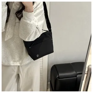 Casual nylon crossbody bag for women, versatile black shoulder bag for daily commute and travel.