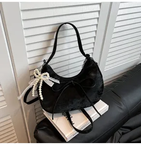 Détail du sac porté épaule en velours noir, charmant nœud en perles, sac tendance rétro.